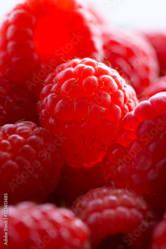 Macro shot of freshly picked organic raspberries. High resolution, backlight