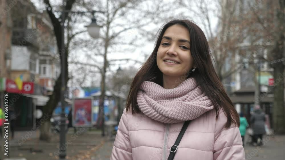 Jolly and beautiful brunette girl enjoying her life in a street full of trees in autumn Jolly and beautiful brunette girl enjoying her life in a street full of trees in autumn