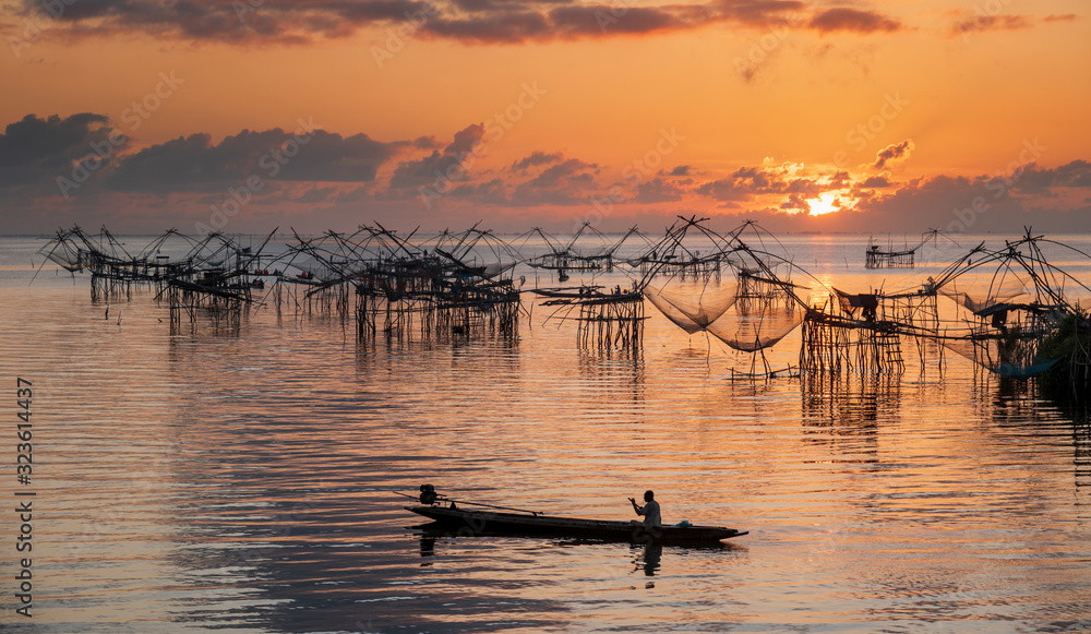 Beautiful golden morning sky and lake and giant bamboo fishing gears at Pakpra village.