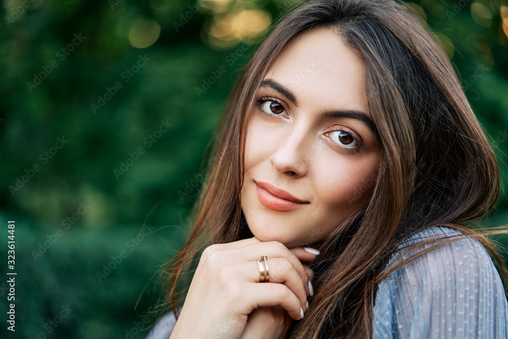 Obraz premium Young beautiful woman outdoors on green background summer nature