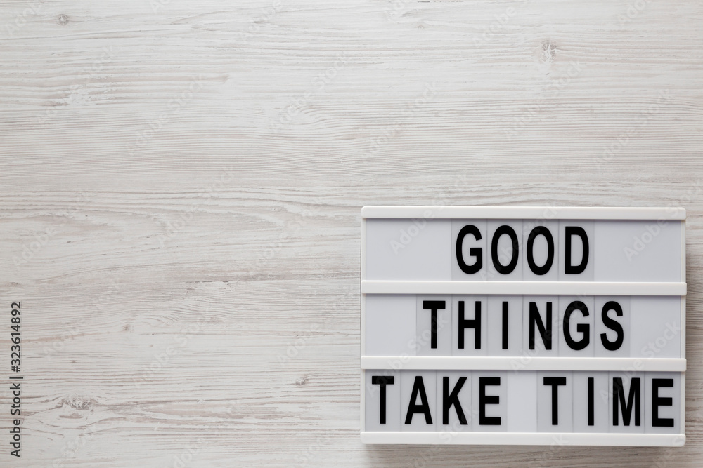 'Good things take time' words on a modern board on a white wooden background, top view. Overhead, from above, flat lay. Copy space. 'Good things take time' words on a modern board on a white wooden background, top view. Overhead, from above, flat lay. Copy space.