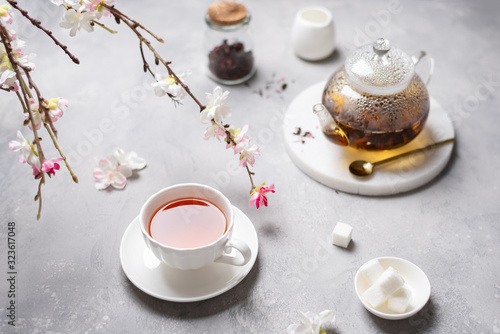 Spring tea party, ceremony. A cup of black tea with sakura branches. Top view, copy space. Poster, greeting card, menu