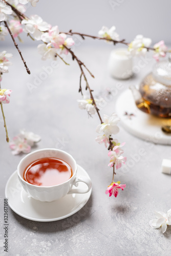 Spring composition. Cup of black tea and sakura branches. Tea party, poster, menu, greeting card concept. Copy space