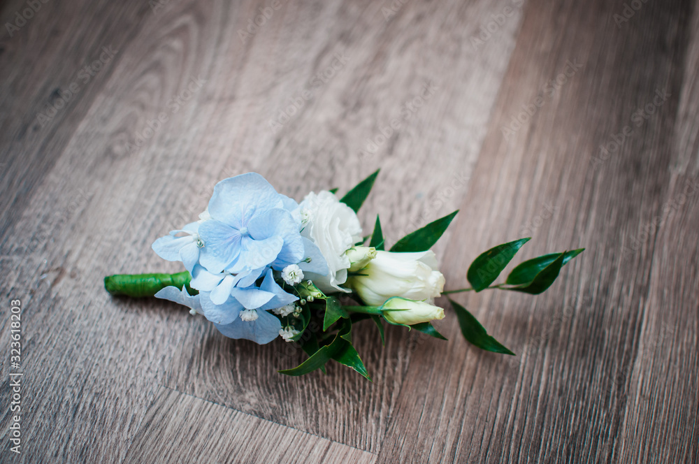 White with blue rose buttonhole on the table White with blue rose buttonhole on the table