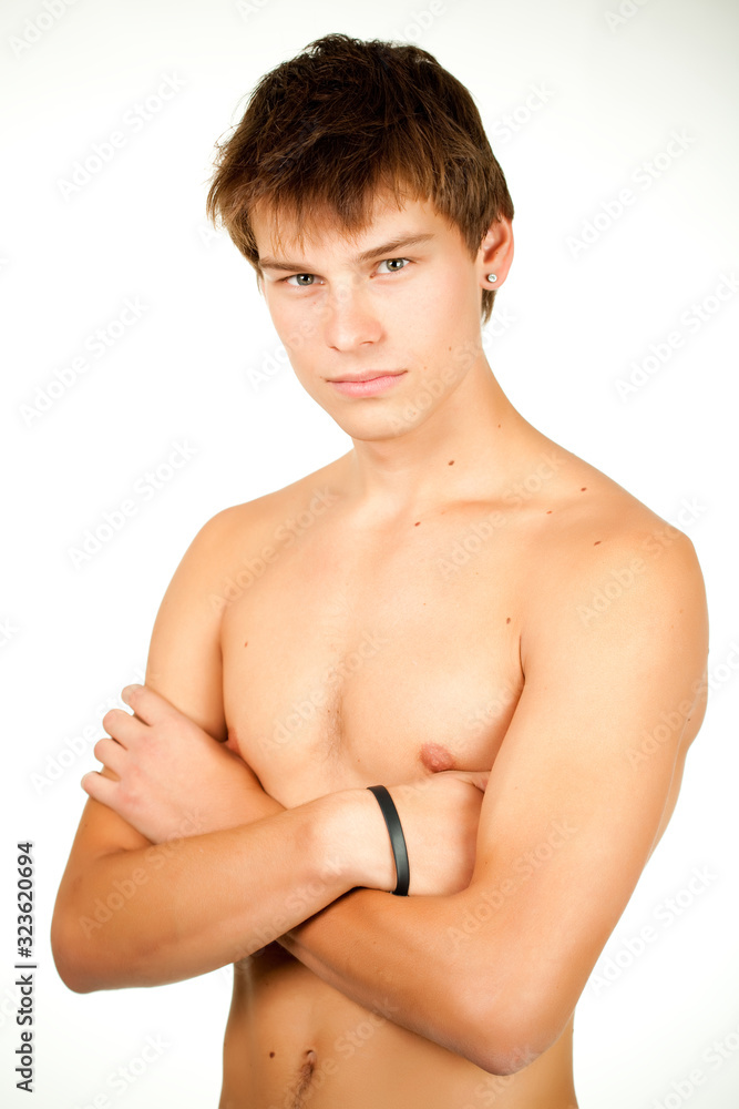 Obraz premium Portrait of a handsome caucasian young guy with a naked torso dosing on a white background. Concept of sport lifestyle and healthy eating. Place for advertising