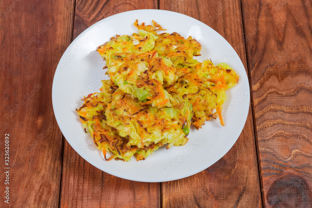 Savory cabbage pancakes on dish on rustic table Savory cabbage pancakes on dish on rustic table
