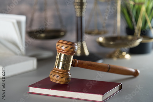 Law and Justice concept. Mallet of the judge, books, scales of justice. Gray stone background, reflections on the floor, place for typography. Courtroom theme.. Wooden rustic background photo