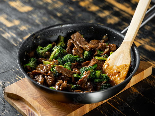 Beef meat and broccoli vegetable cooking in pan close up, selective focus. Traditional food recipe.