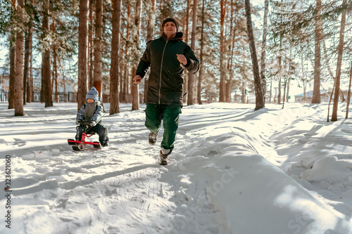 men running with child on the sledge