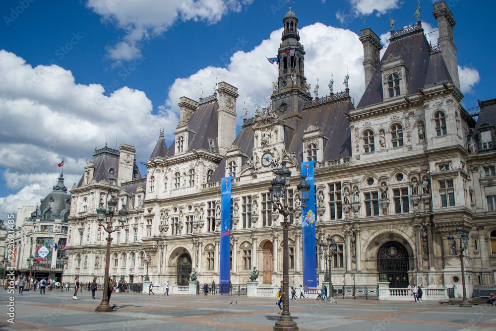 The Hotel de Ville - the city's local administration, Renaissance Revival style. Beautiful sunny day. Paris City Hall against the blue sky with white cumulus clouds.