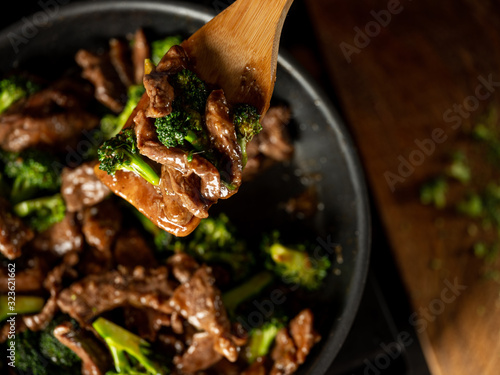 Beef meat and broccoli vegetable cooking in pan close up, selective focus. Traditional food recipe.