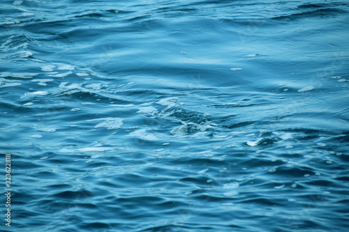 blue sea, ocean waves, water with foam and bubbles, texture, water natural resources concept, close-up, copy space