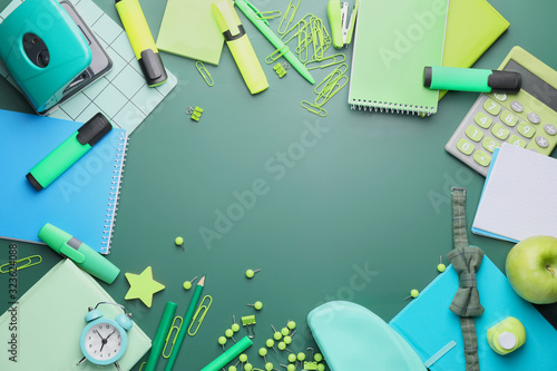 Set of school stationery on green background