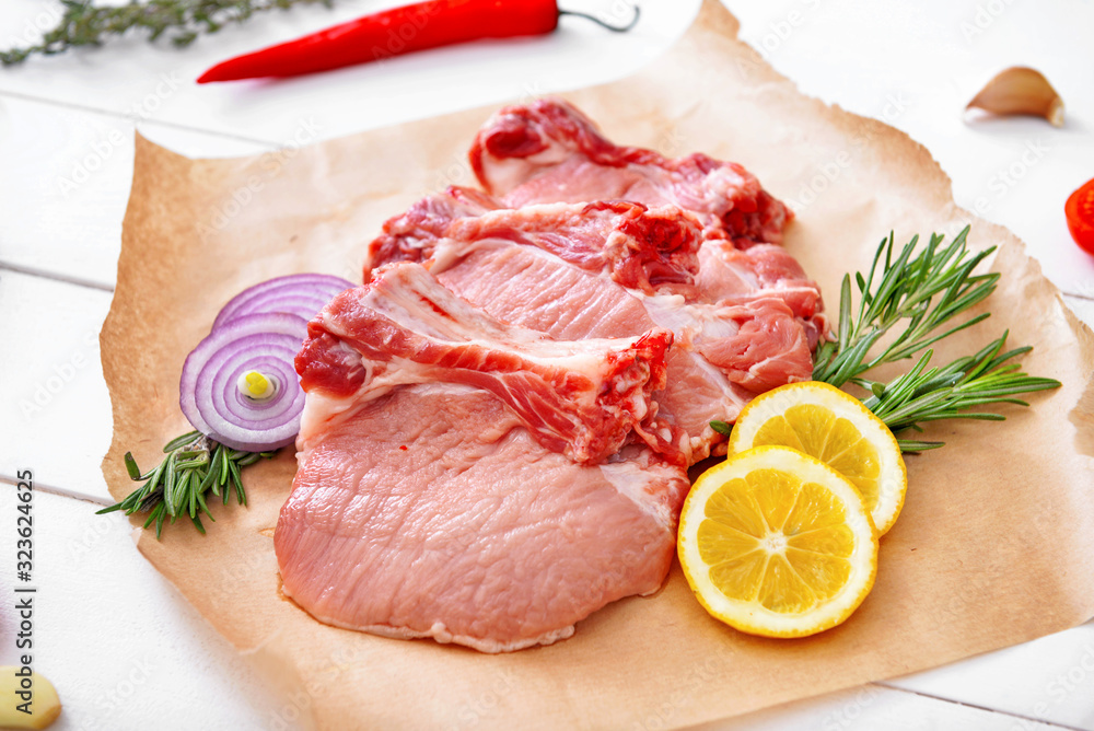 Raw pork meat with vegetables and herbs on table Raw pork meat with vegetables and herbs on table