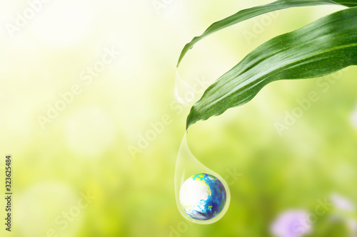 Earth in water drop under the green leaf
