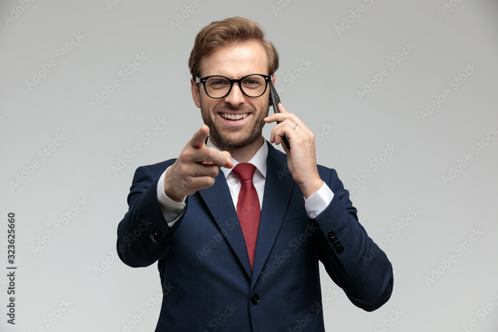 businessman talking on the phone while pointing forward businessman talking on the phone while pointing forward