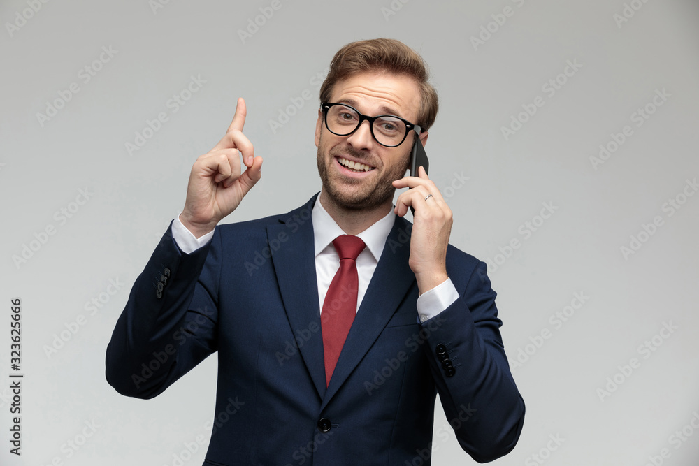 businessman talking on the phone while pointing up businessman talking on the phone while pointing up