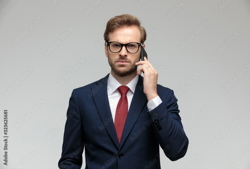 businessman talking on the phone while looking at camera angry - obrazy, fototapety, plakaty 
