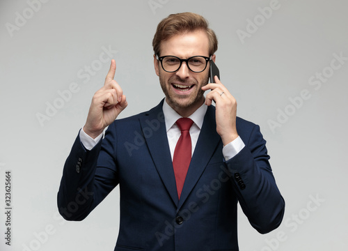 businessman talking on the phone while pointing up