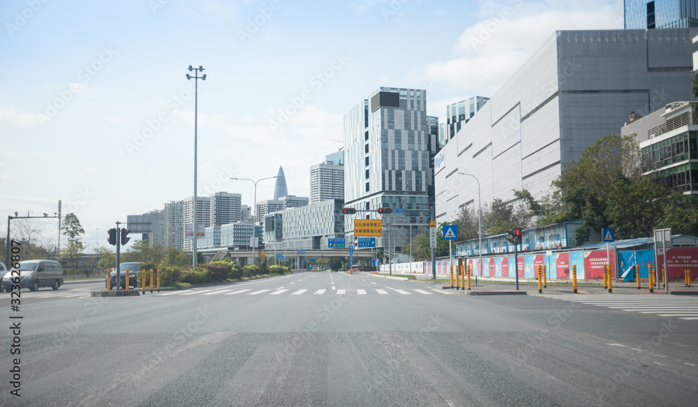 Shenzhen/China - February,2020:  Street scene during the outbreak of Novel Coronavirus in Shenzhen city. Few Vehicles and People on street, Everyone wear face mask.