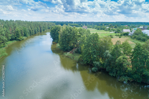 View from above of the countryside and river on a sunny day. Nature landscape with a beautiful cloudy sky. Early spring © vvvita