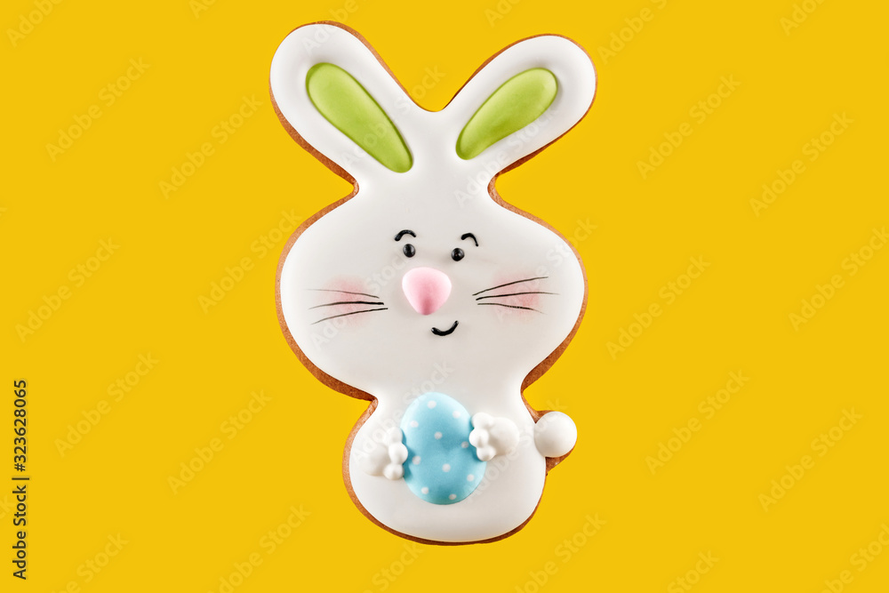 Obraz premium Easter bunny cookie with blue egg over yellow background