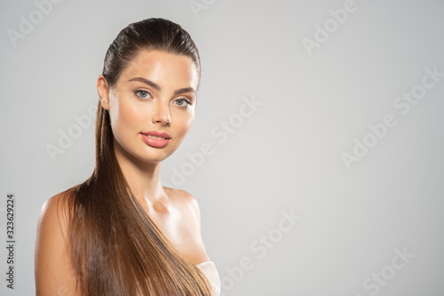 Portrait of a beautiful woman with a long hair. Young brunette model with beautiful hair - isolated on white background. Young girl with clean fresh skin oа a face.