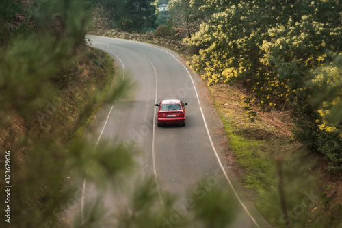 carretera de montaña con un auto rojo
