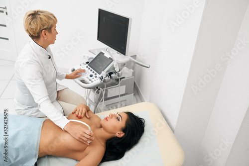 Charming girl getting medical check up of breast condition