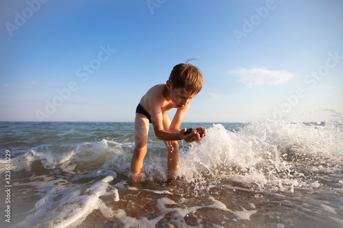 Child on vacation. A boy is playing at sea.