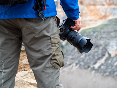 Detail of a man holding a camera in the mountain