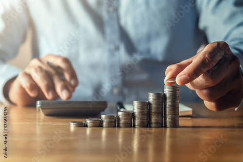 saving money with hand putting coins on stack concept financial