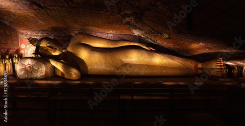 Lying Buddha insides in ancient Buddhist complex in Dambulla cave temple in Sri Lanka. Huge sculpture. photo
