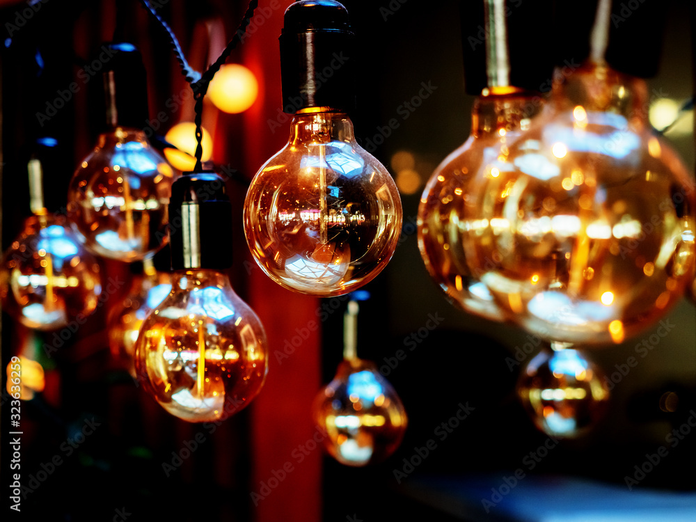 Close-up photo of glossy bulbs hanging on a dark background Close-up photo of glossy bulbs hanging on a dark background