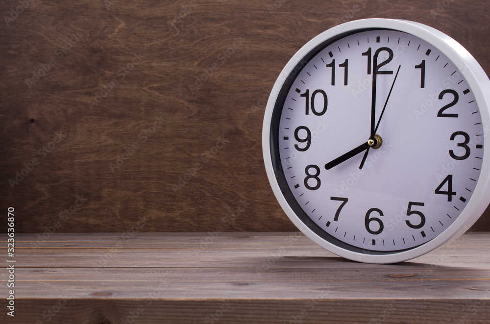 wall clock at wooden table background wall clock at wooden table background