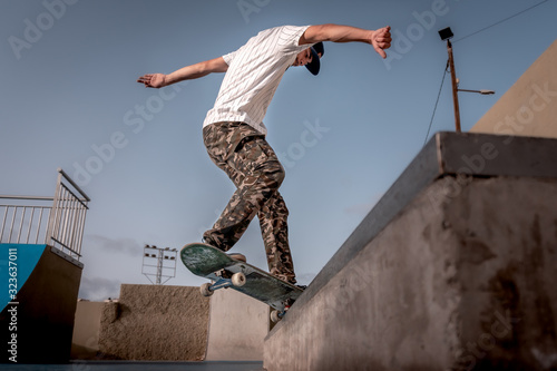 joven patinador hace un truco llamado frontside croocked en un skate park photo