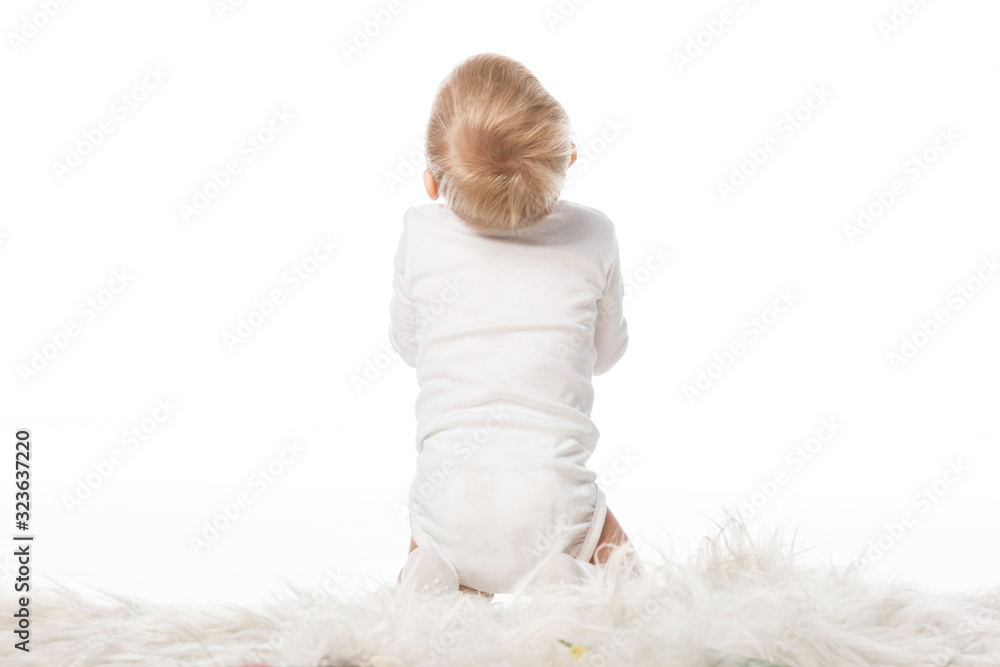 Back view of cute child sitting on fur isolated on white Back view of cute child sitting on fur isolated on white