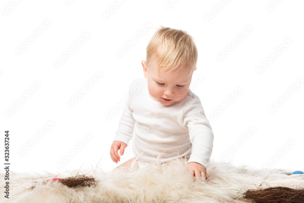 Child looking down, sitting on fur with nests isolated on white Child looking down, sitting on fur with nests isolated on white