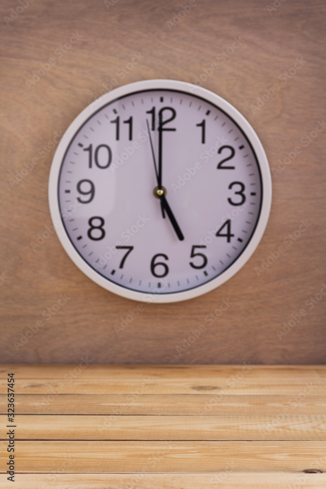 wall clock at wall near wooden table wall clock at wall near wooden table