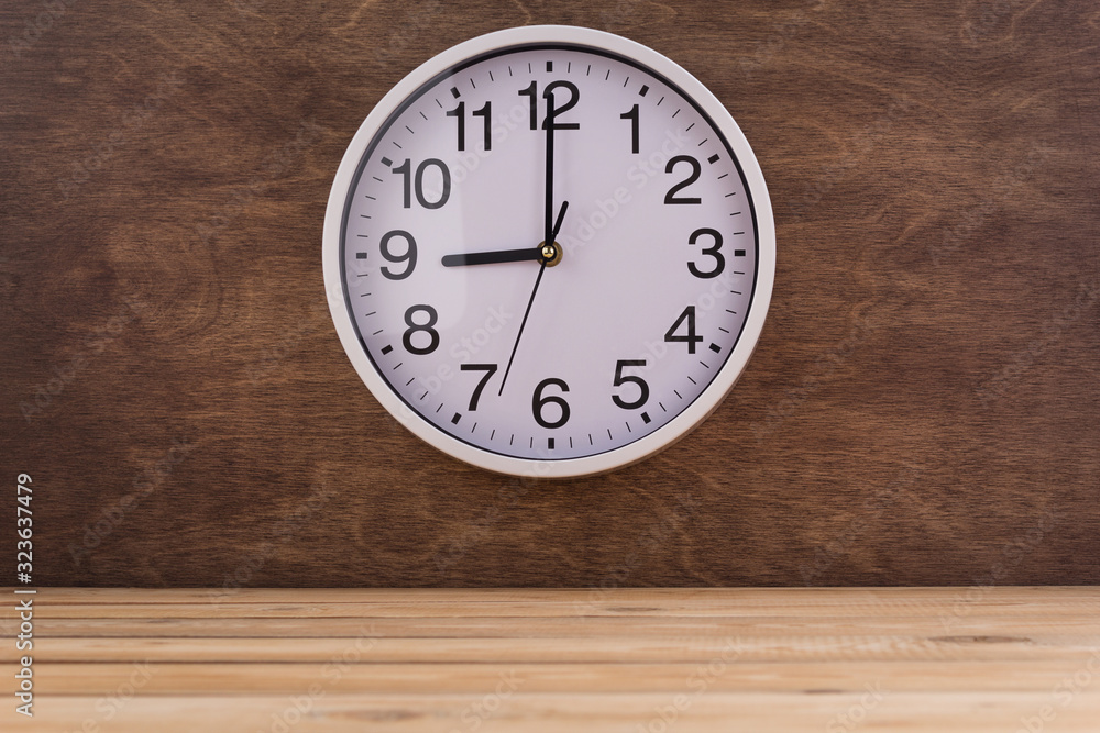 wall clock at wall near wooden table wall clock at wall near wooden table