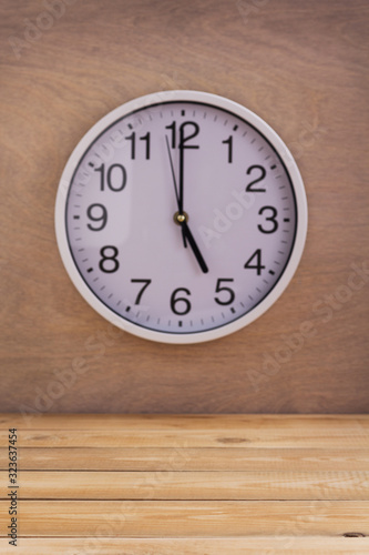 wall clock at wall near wooden table