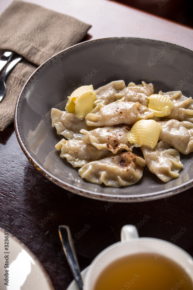 Dumplings, Varenyky, vareniki, pierogi, pyrohy filled with curd cheese on wooden table at restaurant Dumplings, Varenyky, vareniki, pierogi, pyrohy filled with curd cheese on wooden table at restaurant