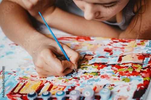 Young teen girl enjoying painting by numbers picture. Creative hobby. Leisure activity.