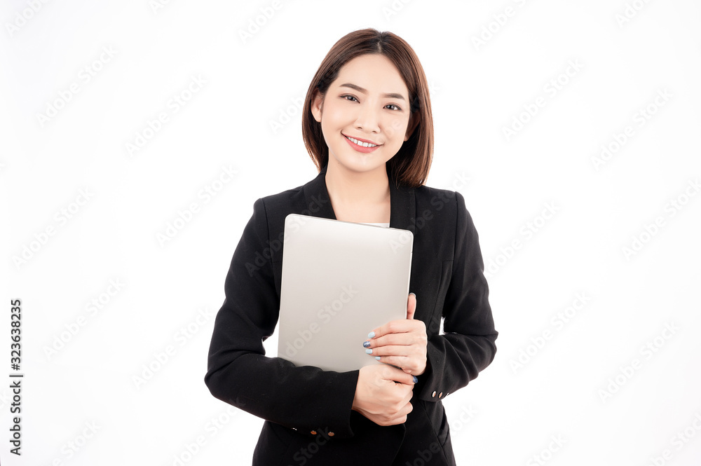 Asian businesswoman with black suit holding a laptop with big smile beaming face in white isolated background. Asian businesswoman with black suit holding a laptop with big smile beaming face in white isolated background.