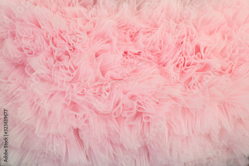 Textured background of ruffled wavy fabric pastel colour- pink. photo