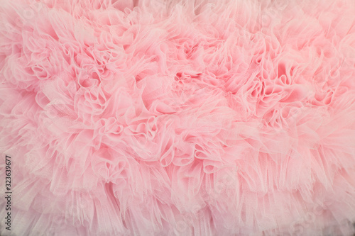 Textured background of ruffled wavy fabric pastel colour- pink.