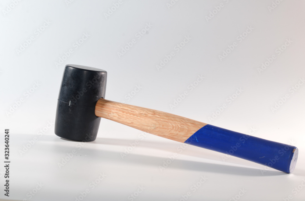 A rubber hammer with a blue wooden handle on a white background A rubber hammer with a blue wooden handle on a white background