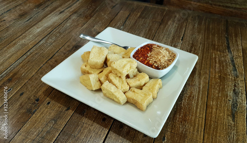 Deep fried crispy tofu in small bite serving with sweet dipping sauce with grounded peanut and chili powder
