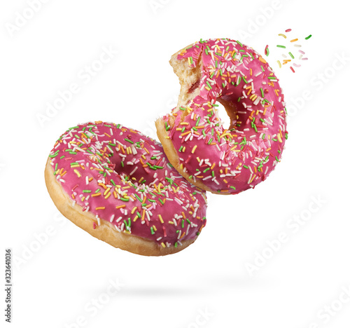 Billede på lærred flying bitten red glazed round donuts with sprinkles isolated
