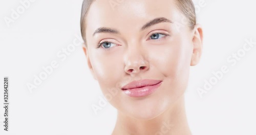 Close up of beauty woman face with blue eyes looking at camera, isolated on white. Beautiful female model with perfect clean fresh skin. Skin care treatment ads